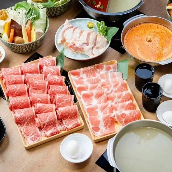 肉盤、蔬菜與多種湯底組成的鍋物餐桌