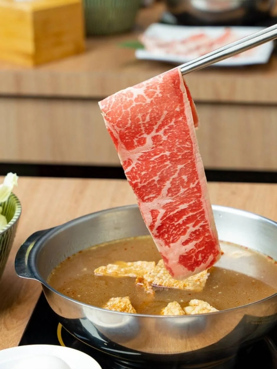 筷子夾起一片油花肉片,準備放入湯鍋