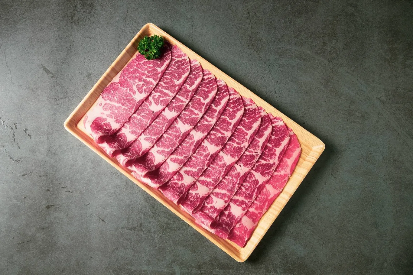 木盤上層層展開的油花薄切肉片