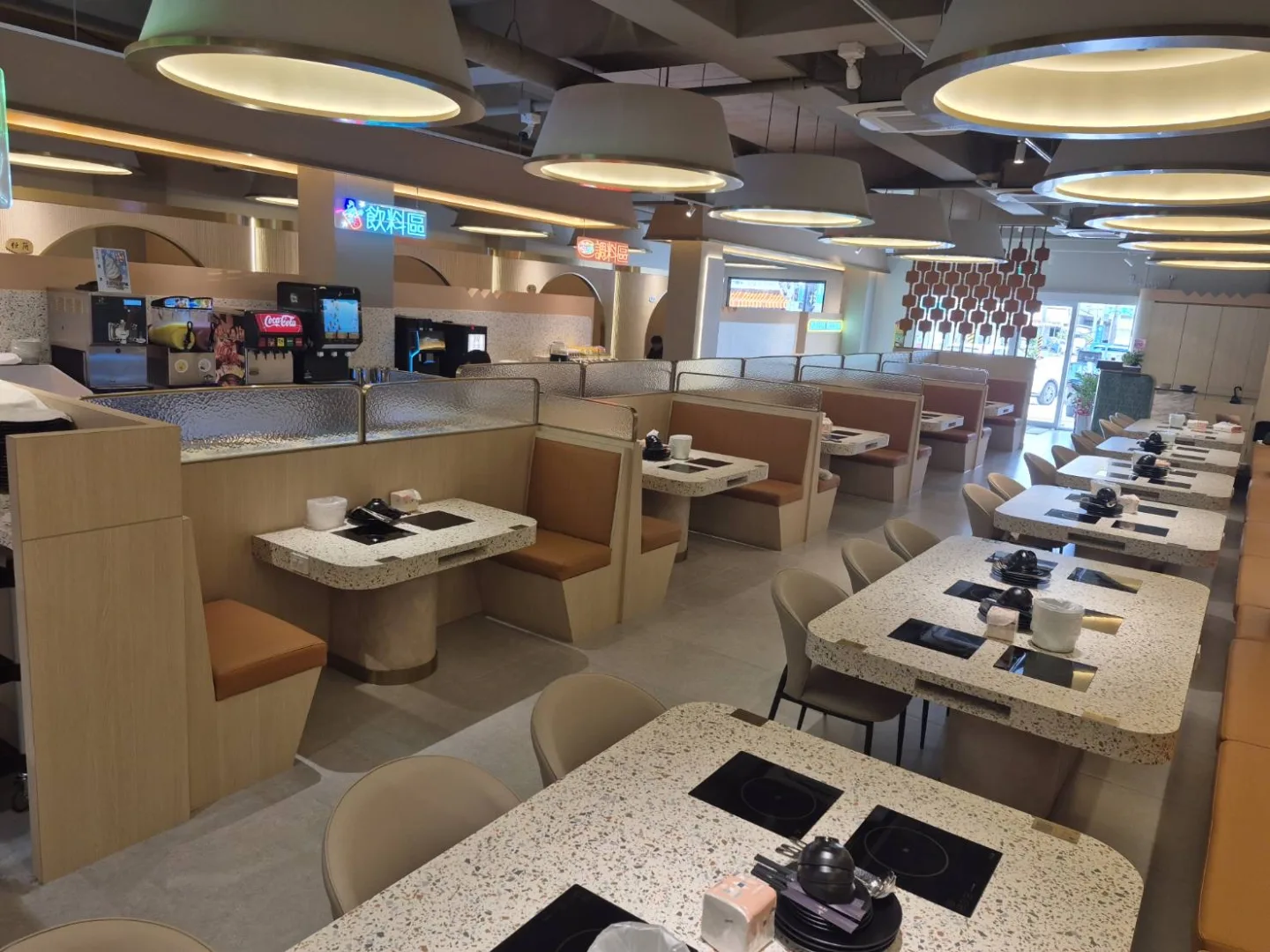 圓形燈具下排列整齊的火鍋餐桌與座位