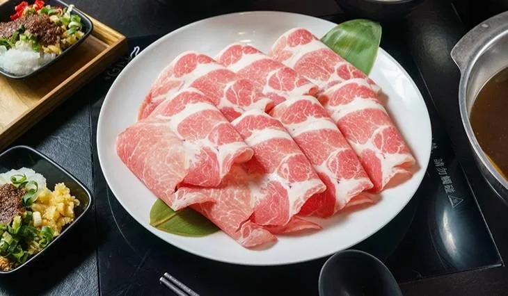 白盤上摺疊排列的粉紅色薄切肉片