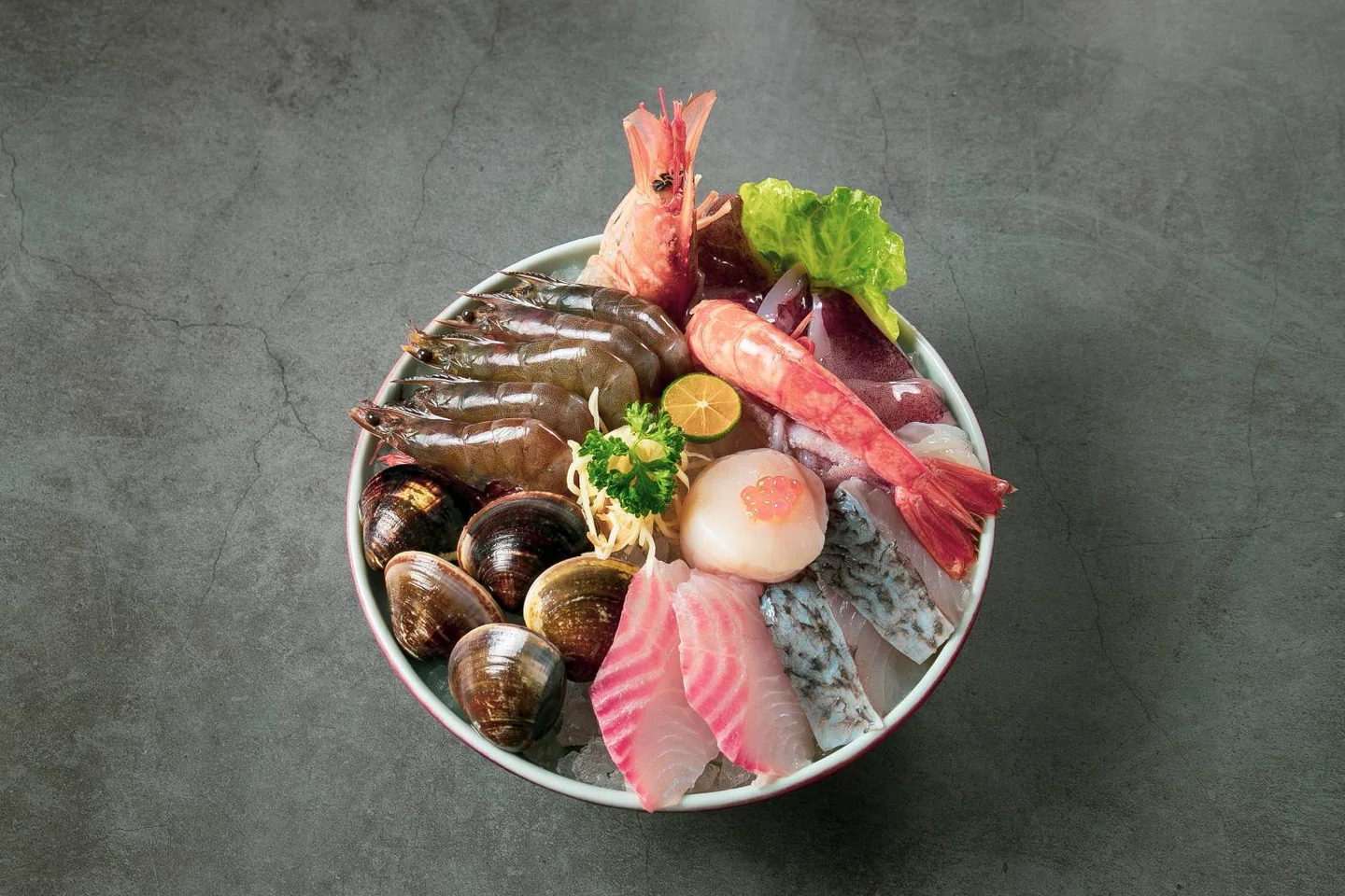 冰盤上整齊盛放蝦、魚片、蛤蜊與花枝的海鮮拼盤