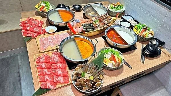 多鍋湯底、肉盤、海鮮與蔬菜圍成的一桌鍋物